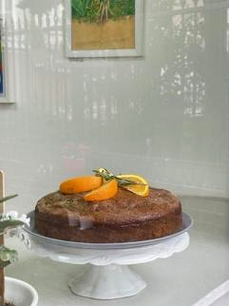 Orange and rosemary cake on a cake stand